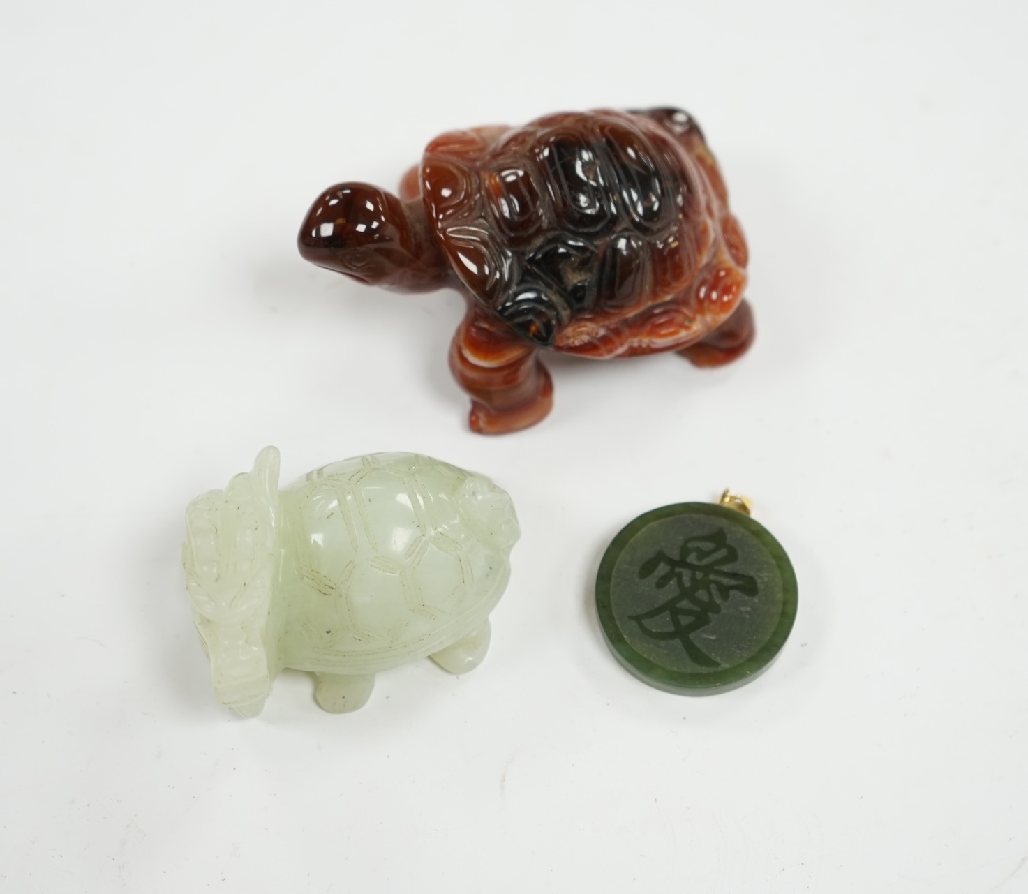 A Chinese carved bowenite dragon, an agate tortoise and a hardstone green circular pendant disc, largest 8cm long. Condition - good